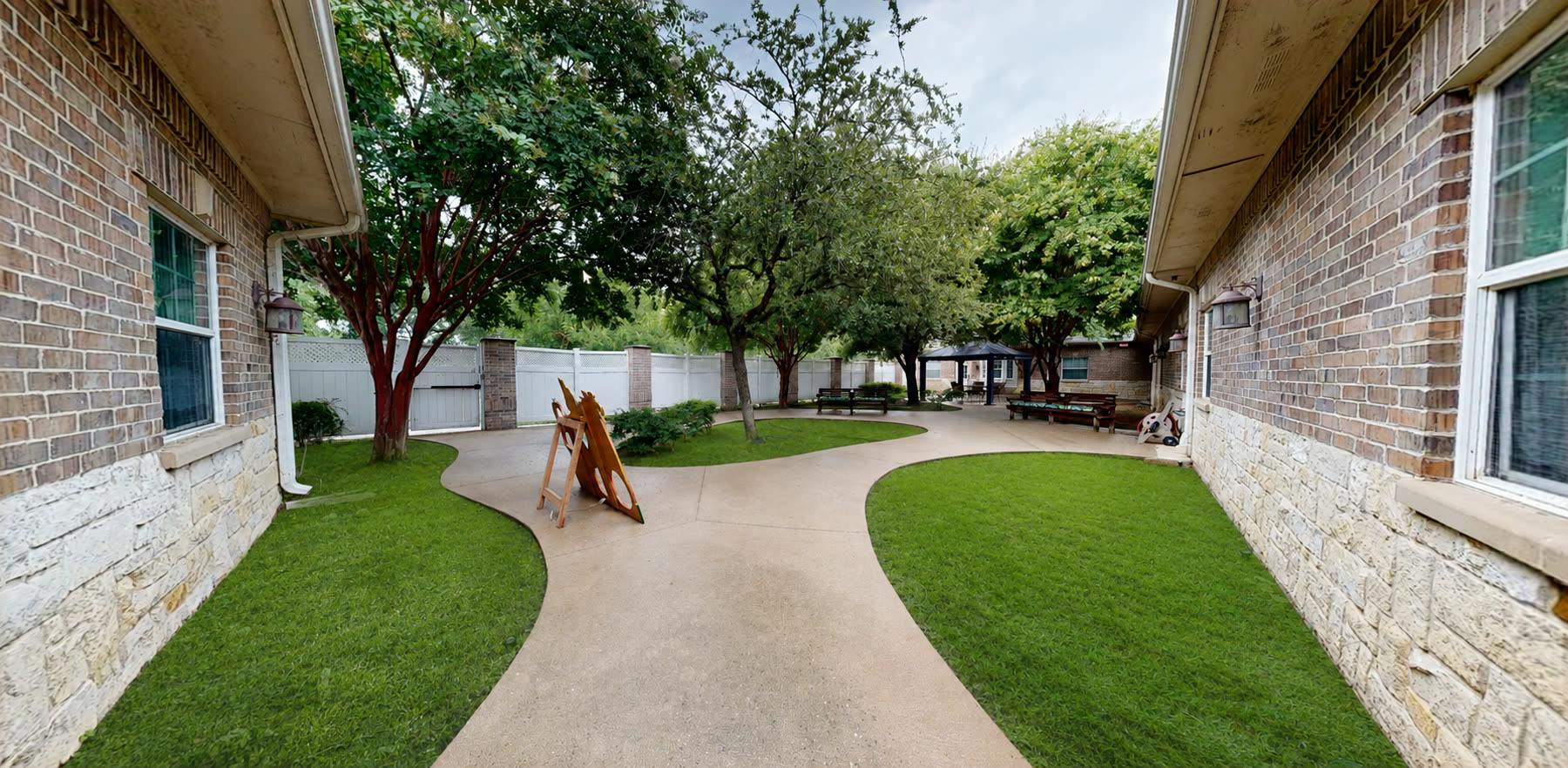 Secure courtyard with walking paths, shade trees, and benches